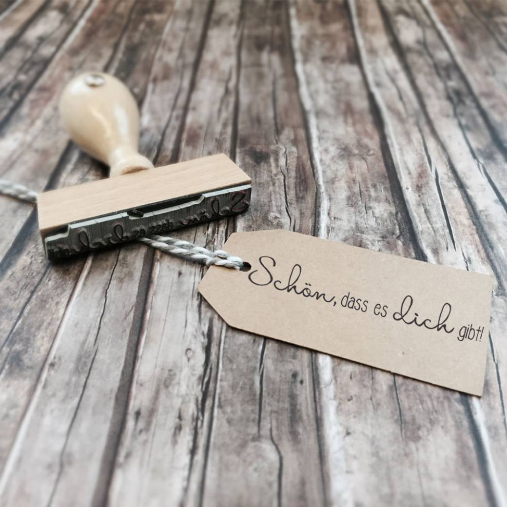 Holzstempel mit dem Schriftzug "Schön, dass es Dich gibt". Holzstempel mit dem Schriftzug "Schön, dass es Dich gibt".